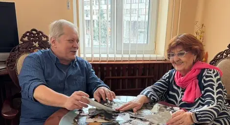 Младен Любенов и Маргарита Трифонова разглеждат снимки от старите албуми.