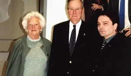 Rossin с президента Буш-старши и неговата съпруга Барбара Буш, пред портрета на двамата Буш - баща и син, който му отваря вратите към президентската институция.