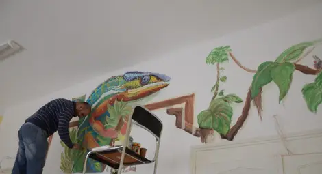 Шарен хамелеон пълзи по стената в Детския отдел на библиотеката