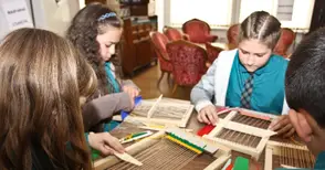 Деца обличат тоги на римски  императори и мелят жито с хромел