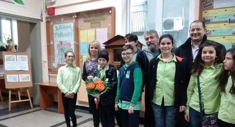 Дамян /детето с букета/ заедно със съученици, преподаватели и художника Валентин Георгиев.                                                                                 Снимка: Фейсбук