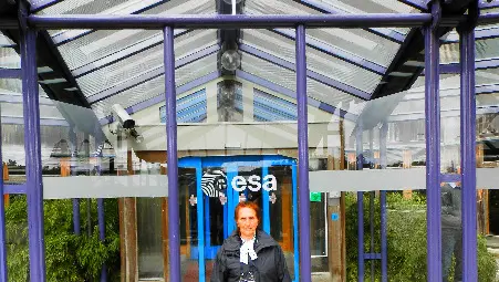 Трифонка Романова Попниколова пред главния вход на Европейския космически изследователски и технологичен център на Европейската космическа агенция ESA-ESTEC, Ноордвайк, Нидерландия, 2012. 