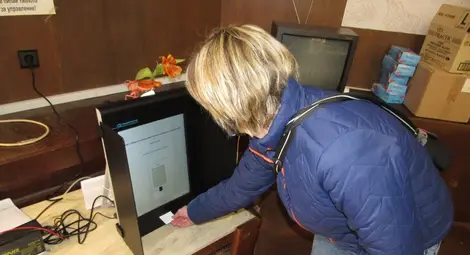 Член на СИК изпробва машинното гласуване.