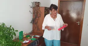 Съдебен помощник тъче бижута от мъниста на ръчно направен стан