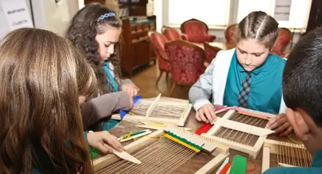 Деца обличат тоги на римски  императори и мелят жито с хромел