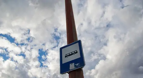 Междуселски автобус профучава през спирка с чакащи пътници