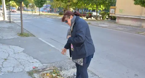 Жена показва дупката, която хората се опитали да запълнят с камъни, но тя все се отваряла.                   Снимка: Бисер ТОДОРОВ