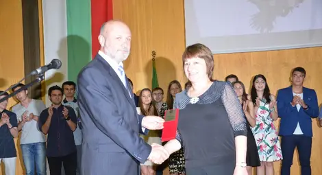 Директорът на гимназията Митко Кунчев връчва на преподавателката по английски Наташа Николова наградата за цялостен принос.                                                Снимка: Красимир СТОЯНОВ