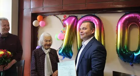 Пенчо Милков връчи на баба Ирина парична награда, а тя обеща да го покани на 101-ия си рожден ден.   Снимка: Община Русе