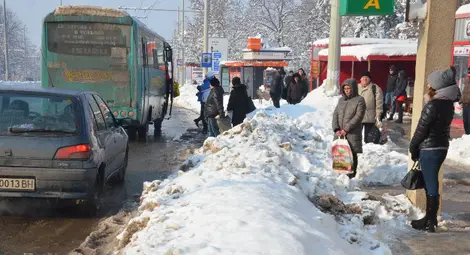 Граждани чакат автобус на пътното платно заради камари сняг