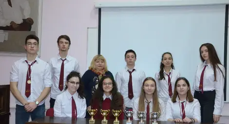 Отборът по дебати със завоюваните купи и медали.