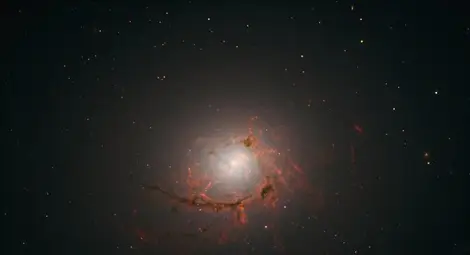 "Хъбъл" засне засмуквана от черна дупка галактика