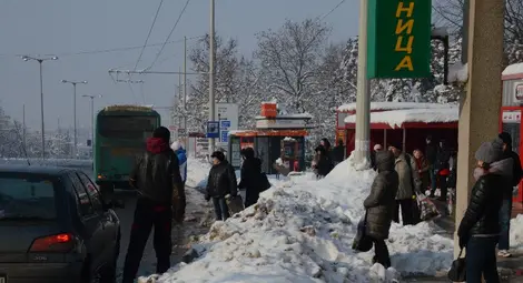Граждани чакат автобус на пътното платно заради камари сняг