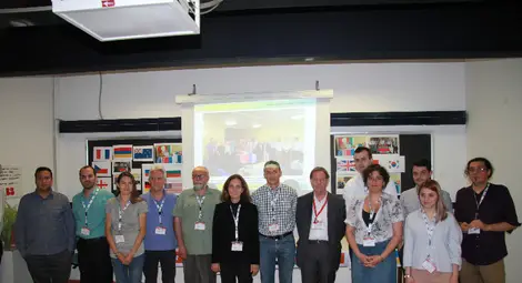 12. Д-р Марияна Георгиева (в средата) с част от участниците в трите си Специални секции на Международния симпозиум Напредък в електромагнитните изследвания &ndash; PIERS, Рим, Италия, 2019, с българското знаме и знамената на 24-те страни-участнички от 6-те населени континента.