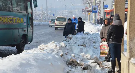 Граждани чакат автобус на пътното платно заради камари сняг
