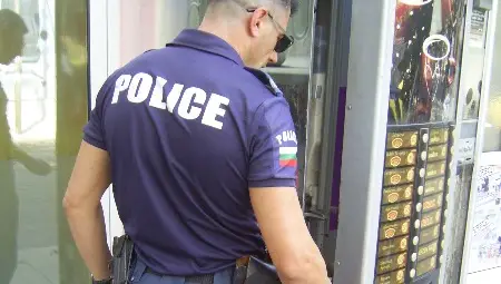 Полицай прави оглед на разбитата кафе машина на ул.&ldquo;К.Иречек&ldquo;. 					         Снимки: Авторът