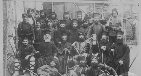 Покръстителната чета на Тане Николов (в средата). Пред войводата е легнал Мамин Колю. Отдясно на войводата е отец Ной Ангелов (поп Нойко), а преди него е отец Стронгелов от Турян. Отляво на войводата, до момиченцето, е архимандрит Стоян Шоков, бъдещият екзарх Стефан.