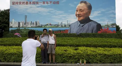 Китайци се снимат на фона на билборд с Дън Сяопин - най-важния лидер в новата история на страната.